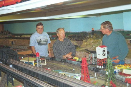 Richard (center) explains layout to Alex and Norm. He received his first set in 1948.