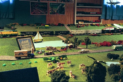 View of neighboring farms with models of cows, farm equipment, and a sailboat on a pond.